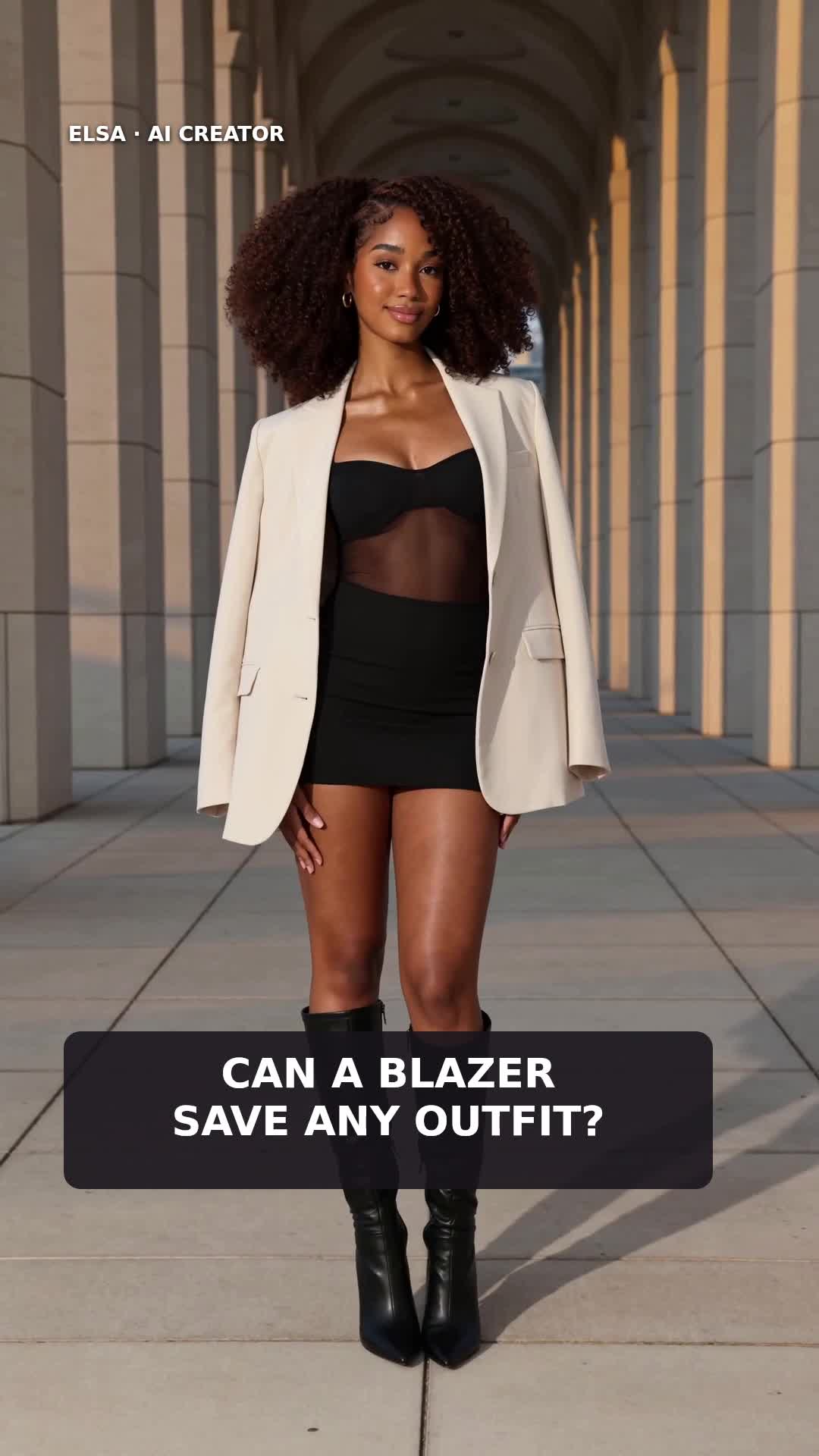 Elsa in an ivory blazer over a short black outfit with tall black boots.